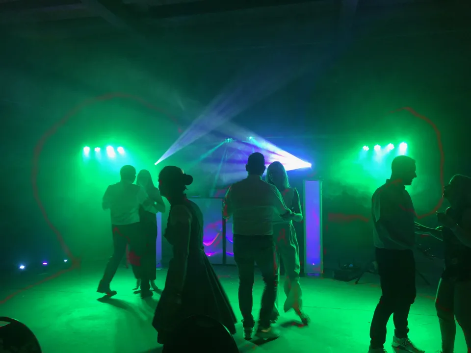 Tanzende Hochzeitsgäste in grünem Lichtkonzept in der Alten Remise Weimar-Tiefurt