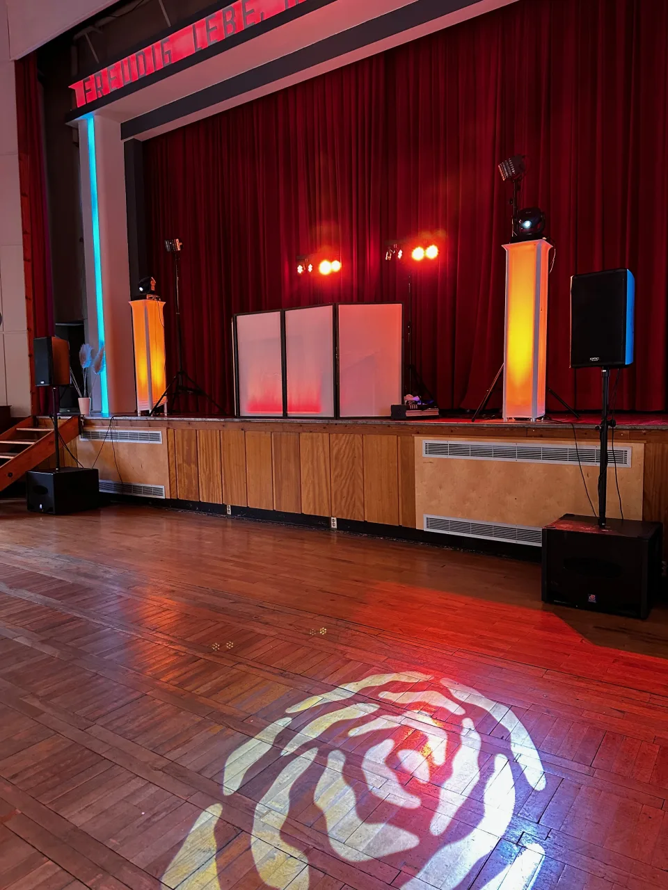 DJ-Setup auf der Bühne im Haus des Volkes Probstzella mit Rosen-Gobo und farbig beleuchteten Towern
