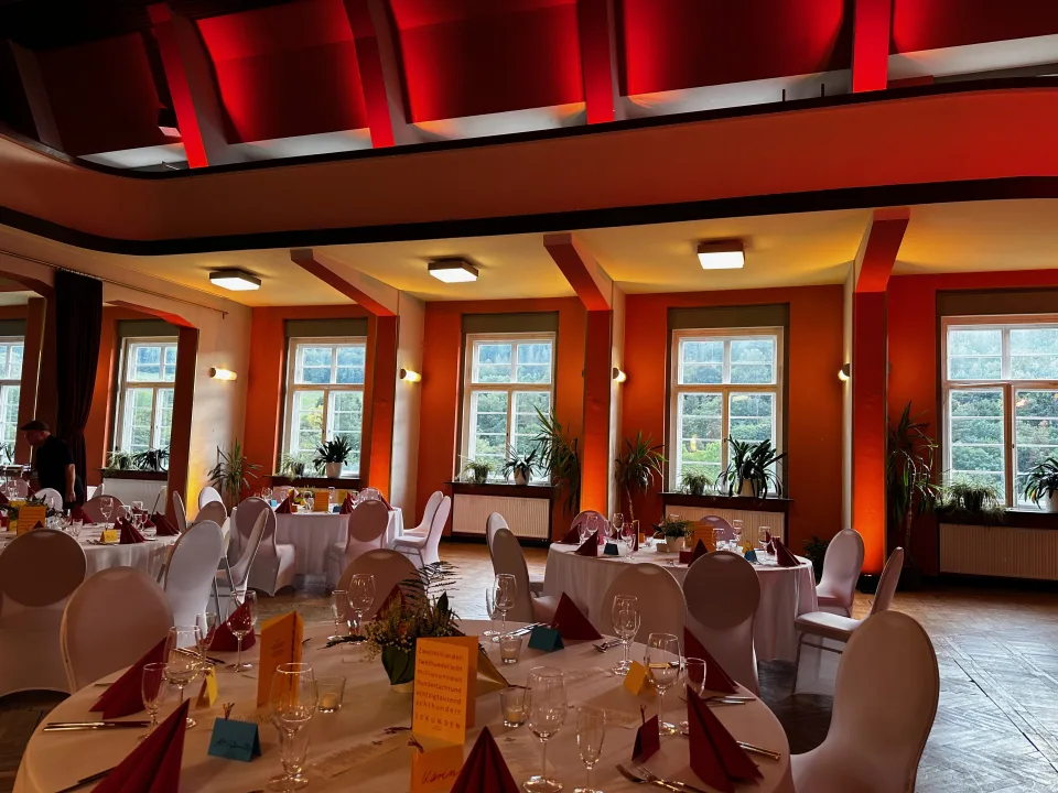 Festlich gedeckte Tische mit bunter Dekoration bei einer Hochzeit im Haus des Volkes Probstzella