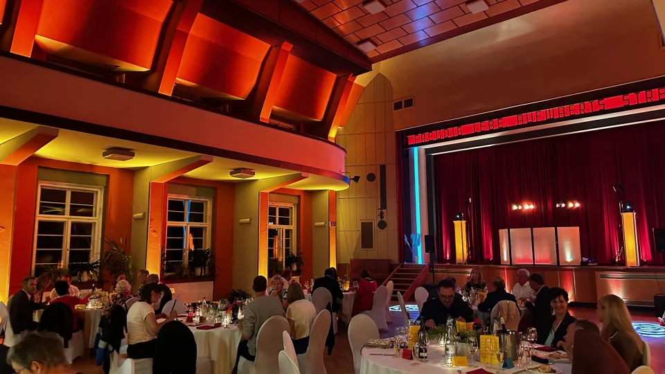 Hochzeitsgesellschaft im warm beleuchteten großen roten Saal des Haus des Volkes Probstzella