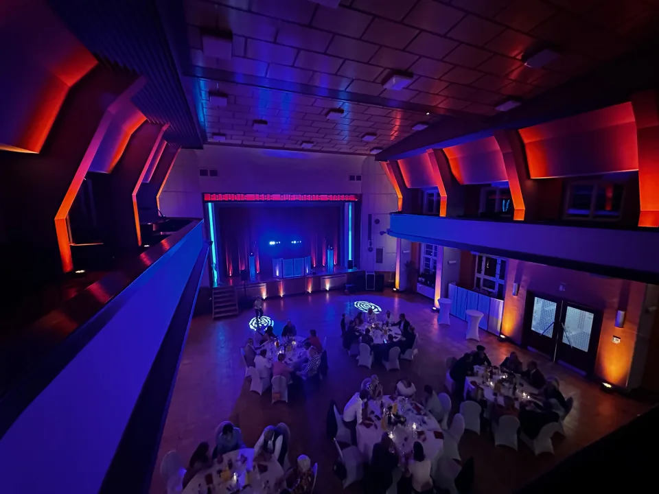 Großer roter Saal im Haus des Volkes Probstzella in blauer und roter Lichtstimmung von der Empore aus