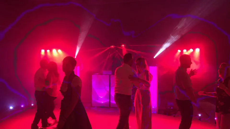 Volle Tanzfläche mit warmem Rotlicht bei einer Hochzeit in der Alten Remise in Weimar-Tiefurt